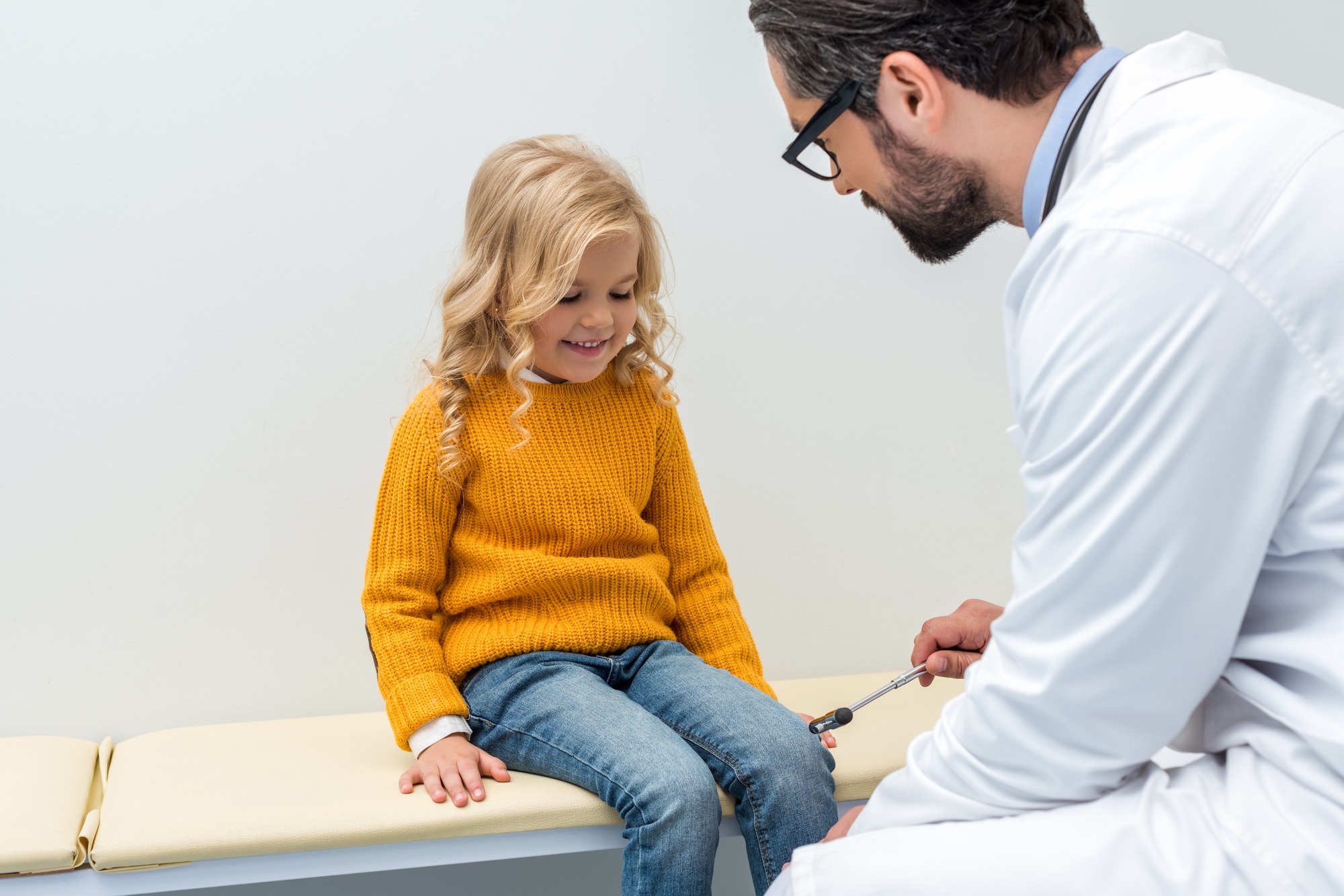 pediatrist making neurology examination for smiling little girl