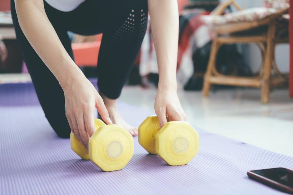 Closeup woman hands holding dumbell.